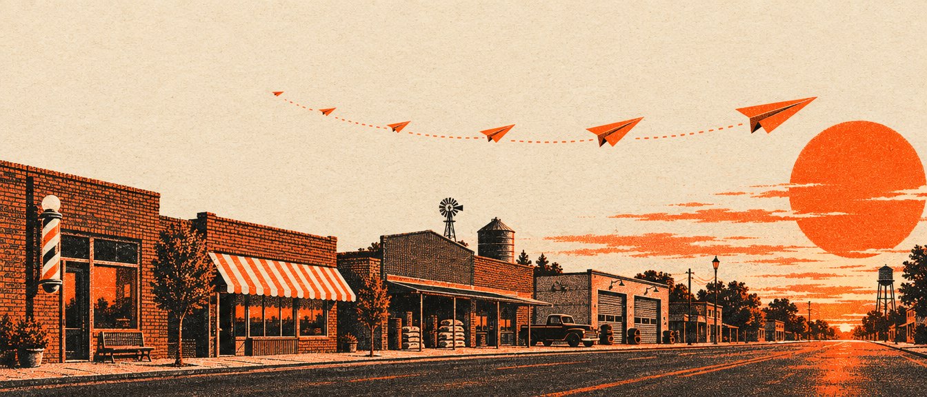 Paper airplanes flying over a small-town main street at sunset
